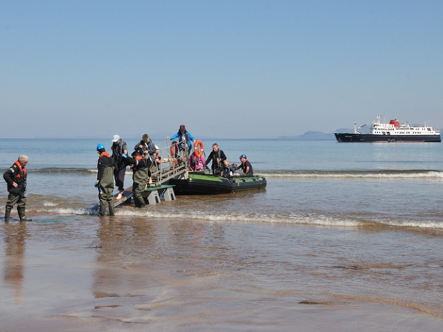 A rib boat from the Hebridean Princess dropping guests off on a beach