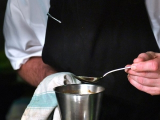 A chef serving food in the Columba Restaurant aboard the Hebridean Princess boat from Hebridean Island Cruises