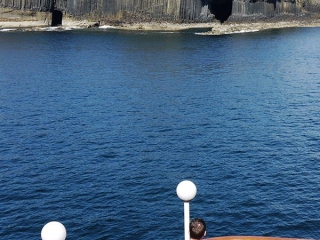 Fingals Cave with guests taking in the view from the Boat Deck on the Hebridean Princess cruise ship of Hebridean Island Cruises