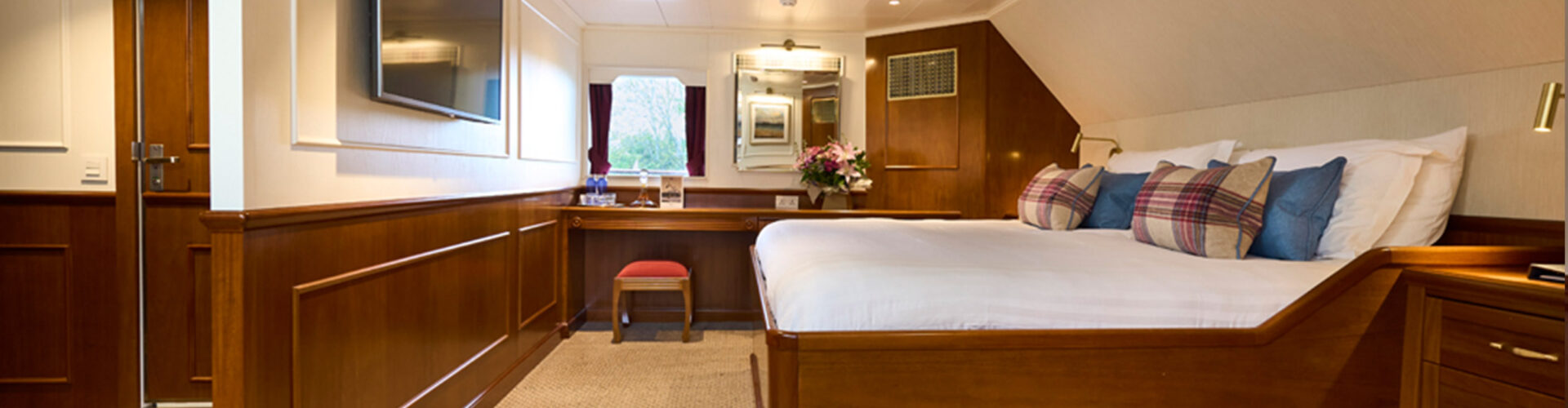 A cabin with its luxurious bed on the Lord of the Highlands cruise ship